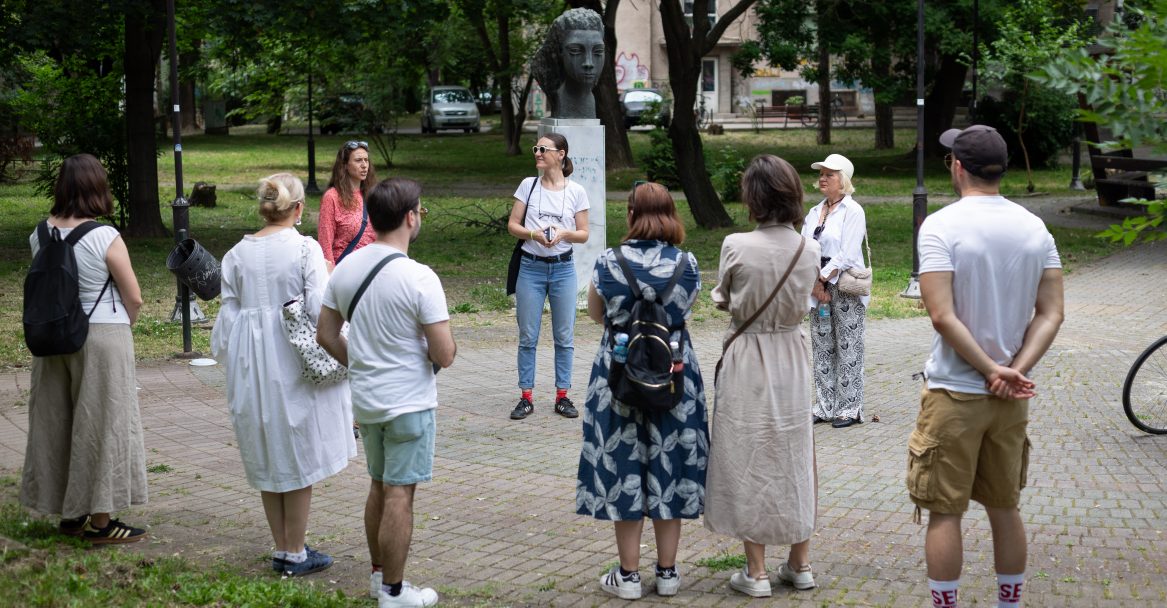 The Feminist City Tour, part of the FIRSTBORN GIRL #12 Festival on June 1, 2024, highlights the histories of notable women from three countries, based on the research publication Our Path. Organized by Tiiiit! Inc. as part of the Women on Women project, the tour was led by sociologist and activist Ivana Dragsic, accompanied by Jana Kocevska, Program Coordinator of Tiiiit! Inc., who are two of the publication’s authors. The group visited sites including a statue honoring Vera Jocikj, a WWII fighter. Photo by: Jelena Belikj